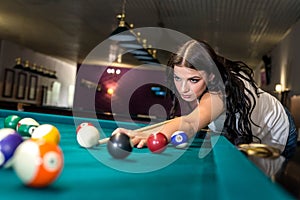 brunette woman concentrated on billiard game