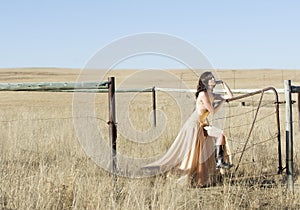 Brunette woman in couture dress in field