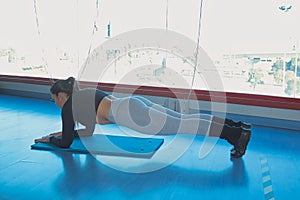 Brunette woman doing abdominal plank in gym