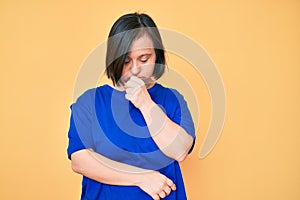 Brunette woman with down syndrome wearing casual clothes feeling unwell and coughing as symptom for cold or bronchitis