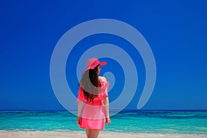 Brunette Woman enjoyng On Tropical Beach. Attractive girl in red