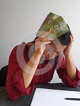 brunette woman with expression of despair and grabbing Chilean money