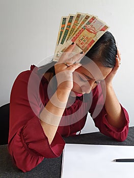 brunette woman with expression of despair and grabbing cuban money