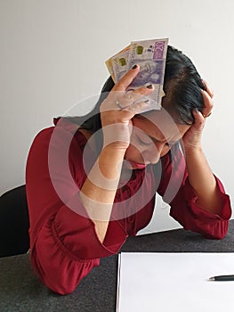 brunette woman with expression of despair and grabbing swedish money
