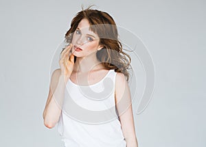 Brunette Woman girl with long and shiny wavy curly hair.