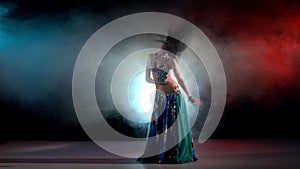 Brunette woman go on performing belly dance, on