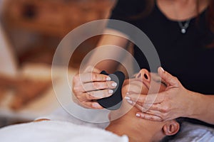 Brunette woman having a stone massage on face