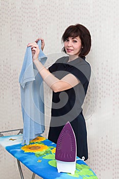 A brunette woman in her apartment with smile irons