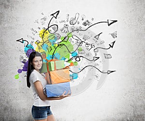 A brunette woman is holding three colourful gift boxes. Drawn sketch on the wall with arrows and shopping icons.