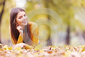 Brunette woman laying in autumn park