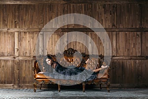 Brunette woman laying on leather sofa.