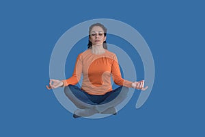 Brunette woman levitating and doing yoga