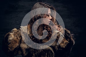 Brunette woman with long curly hair dressed in a fur coat. photo