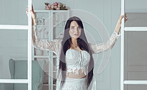 Brunette woman with long hair opening doors in living room