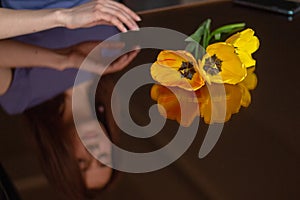 brunette woman looking her reflection in a mirror