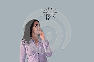 Brunette woman looking at a light bulb