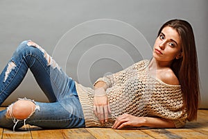 Brunette woman lying on wooden floor