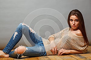 Brunette woman lying on wooden floor