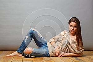 Brunette woman lying on wooden floor