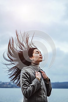 Brunette woman outdoor with blowing up hair