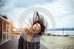 Brunette woman outdoor with blowing up hair