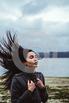 Brunette woman outdoor with blowing up hair