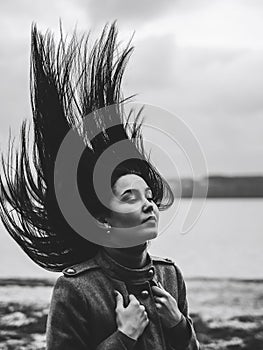 Brunette woman outdoor with blowing up hair