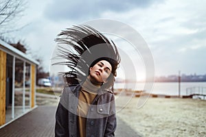 Brunette woman outdoor with blowing up hair