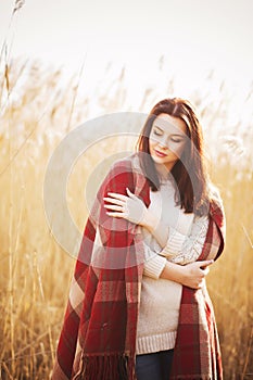 Brunette woman outdoors in check pattern plaid smiling