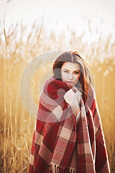 Brunette woman outdoors in check pattern plaid smiling