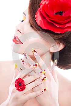 Brunette woman with poppy flower in her hair, poppy ring and creative nails, closed eyes