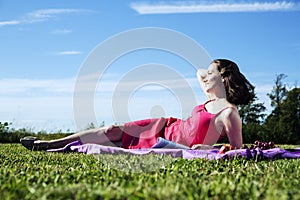 Brunette woman posing elegantly on the grass