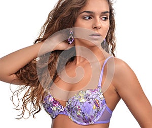 brunette woman posing in purple modern bikini swimsuit and fashion earings