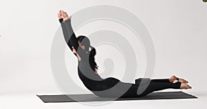 A brunette woman practicing yoga, performs the Makarasana exercise, crocodile or locust pose in dynamics