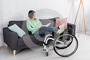 Brunette woman reading book on couch