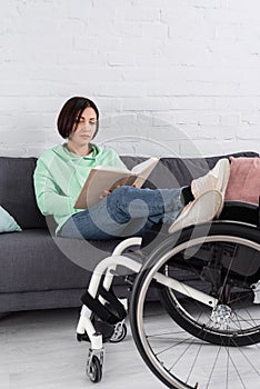 Brunette woman reading book while sitting