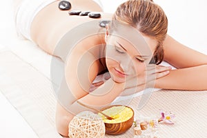Brunette woman receiving spa stones therapy