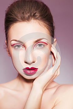 Brunette woman with red full lips and red lines on her eyelids and braid hairstyle