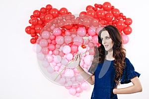 brunette woman with red heart balloons and flowers