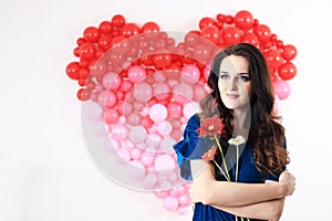 brunette woman with red heart balloons and flowers