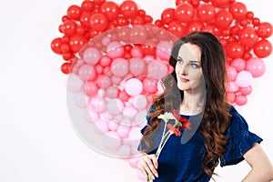 brunette woman with red heart balloons and flowers