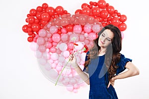 brunette woman with red heart balloons and flowers