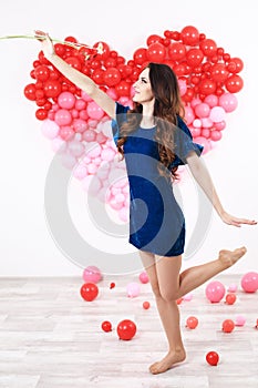 brunette woman with red heart balloons and flowers