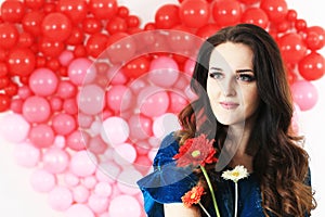 brunette woman with red heart balloons and flowers