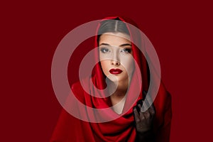 brunette woman with red lips and veil over her head