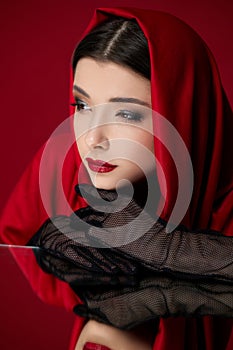 brunette woman with red lips and veil over her head