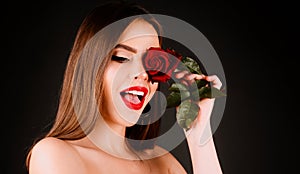 Brunette woman with red rose. Beautiful girl with reses flowers. Closeup face of young beautiful woman with a healthy photo