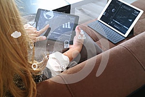 brunette woman using digital talet and laptop computer on sofa i