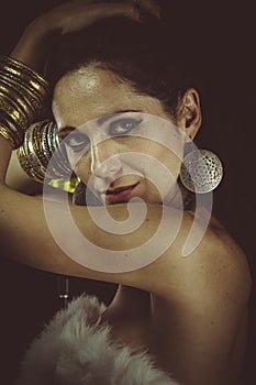 Brunette woman wearing white fur and gold jewelry