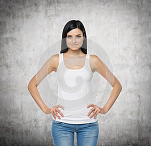 Brunette woman is in a white tank top and blue denims.